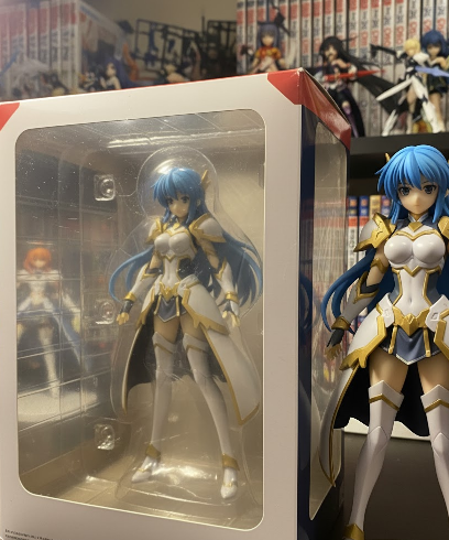 Anime figure displayed beside its original retail box with visible light shelf wear and softened edges